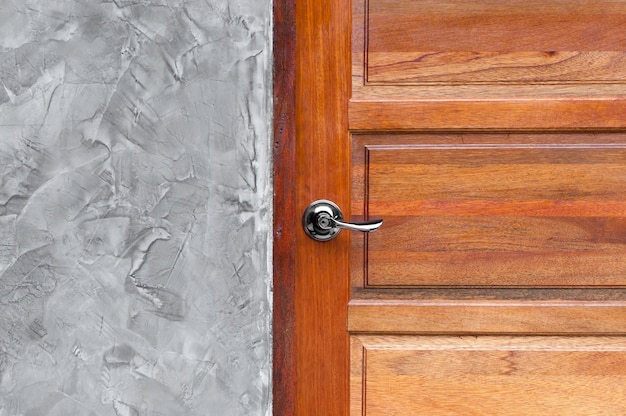 Dettaglio della maniglia della porta metallica in stile moderno sulla porta di legno.Concetto per l'interior design e l'architettura