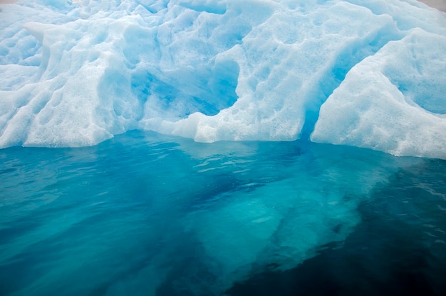 Dettaglio di un iceberg bluastro in acqua limpida