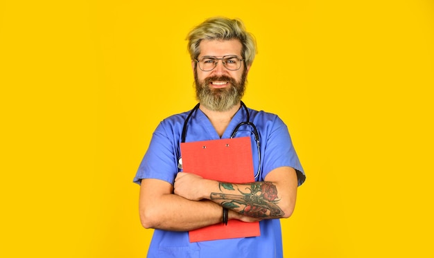 Di buon umore Medico professionista che tiene cartella infermiera barbuta matura che tiene appunti medico maschio usa stetoscopio terapista in uniforme presso ospedale anamnesi e prescrizione medica