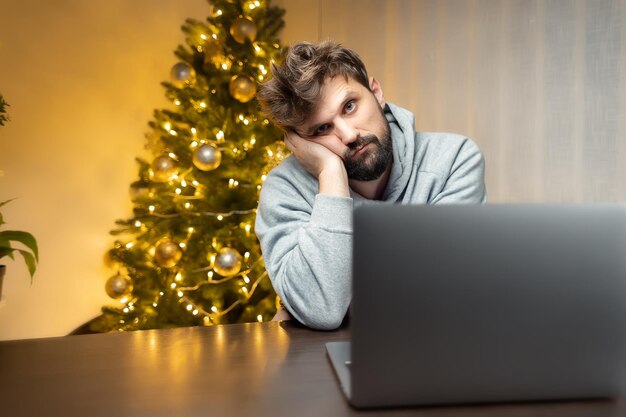 Di notte in ufficio un uomo si siede davanti a un computer alla vigilia di Capodanno