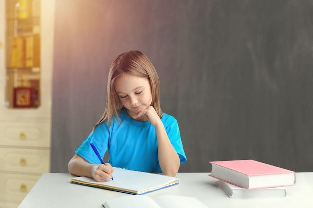 Di nuovo a scuola. Allievo sorridente felice che disegna alla scrivania.