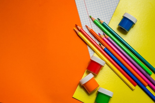 Di nuovo a scuola. Articoli per la scuola su un tavolo arancione. Foto di alta qualità