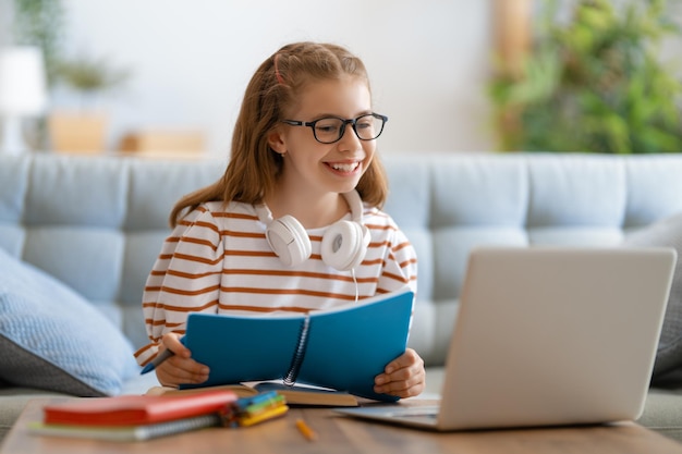 Di nuovo a scuola. Il bambino felice è seduto alla scrivania. Ragazza che fa i compiti o istruzione online.