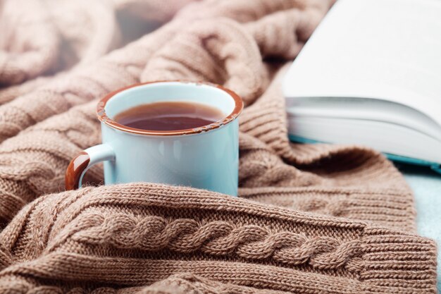 ? di tè caldo, libro aperto e calda coperta lavorata a maglia