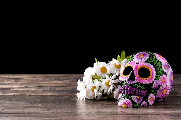 Diadema messicano tipico del cranio e dei fiori sulla tavola di legno Dia de los muertos.