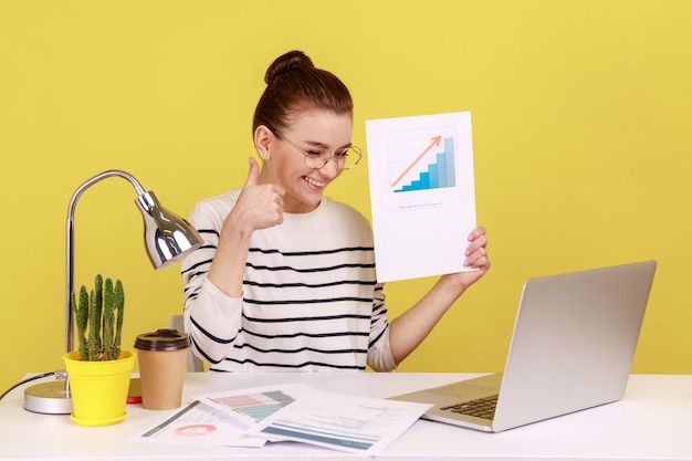 Diagramma di crescita della holding della donna che mostra il pollice fino alla crescita economica e finanziaria dello schermo del laptop