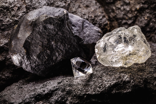 Diamante grezzo accanto a un diamante tagliato, in una miniera di carbone, concetto di estrazione mineraria e minerale
