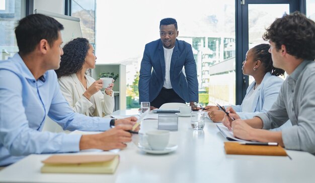 Diamo un'occhiata a questo trimestre Inquadratura di un team di dipendenti che ha una riunione di lavoro per pianificare un progetto nel proprio ufficio