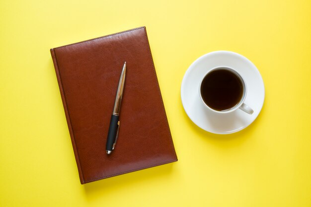 Diario con copertina in pelle e una tazza di caffè