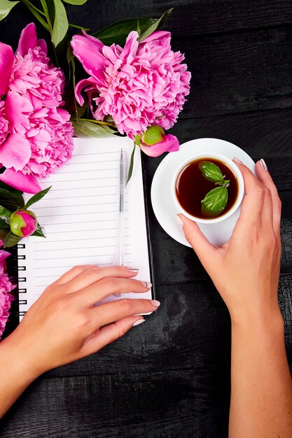 Diario di scrittura della mano della donna, o lettera, nota con la tazza di caffè.