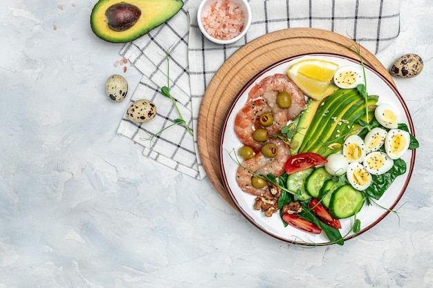 Dieta chetogenica colazione gamberetti gamberi uovo fritto morbido insalata fresca pomodori cetrioli e avocado su sfondo chiaro Keto paleo pranzo Formato banner lungo top