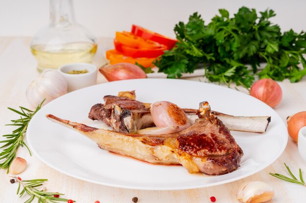 Dieta chetogenica, paleo, lchf - costolette di agnello fritte grasso sul piatto bianco con la verdura