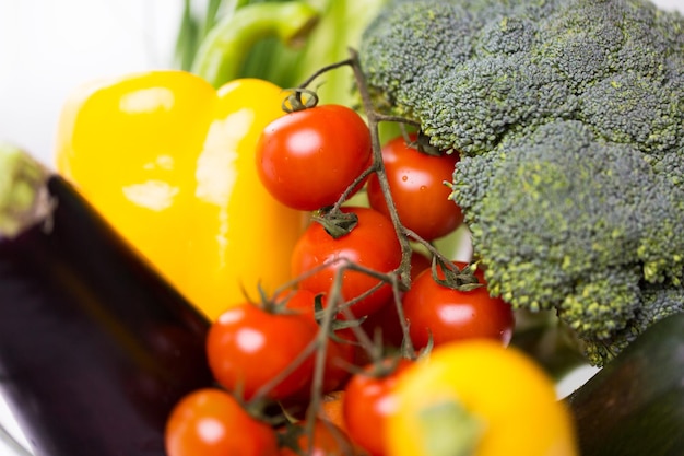 dieta, cibo vegetale, alimentazione sana e concetto di oggetti - primo piano di verdure mature in ciotola di vetro sul tavolo