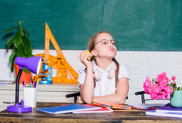 Dieta di cibi crudi bambina pronta da mangiare mela Concetto di bambino intelligente mangiare sano è buono era digitale con tecnologia moderna piccolo bambino geniale in classe Ora di pranzo ritorno a scuola Einstein