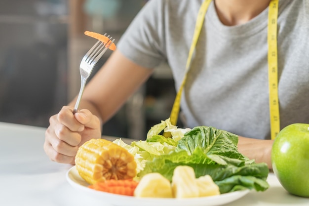 Dieta, dieta giovane donna asiatica o ragazza usa la forchetta alla carota sul piatto di insalata di verdure, mangiare cibo verde è a basso contenuto di grassi buona salute non scegliere mangiare cibo spazzatura. Donna nutrizionista, persona di perdita di peso.