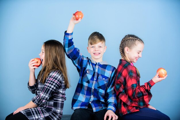 Dieta sana e nutrizione vitaminica Ragazzi e ragazze amici mangiano uno spuntino di mele mentre ci si rilassa Concetto di spuntino scolastico Gruppo adolescenti allegri che comunicano e mangiano mele Adolescenti con uno spuntino sano