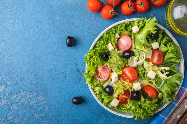 Dieta sana insalata con verdure, pomodorini, cipolla, formaggio e olive nere