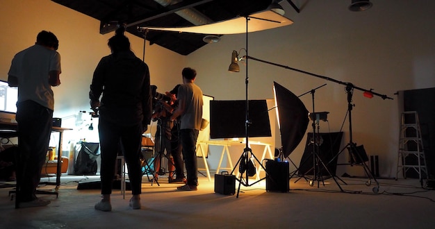 Dietro il team di produzione delle riprese e la silhouette della telecamera e dell'attrezzatura in studio.