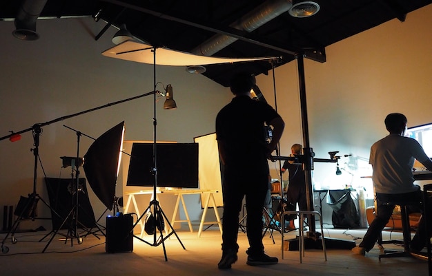 Dietro il team di produzione delle riprese e la silhouette della telecamera e dell'attrezzatura in studio.