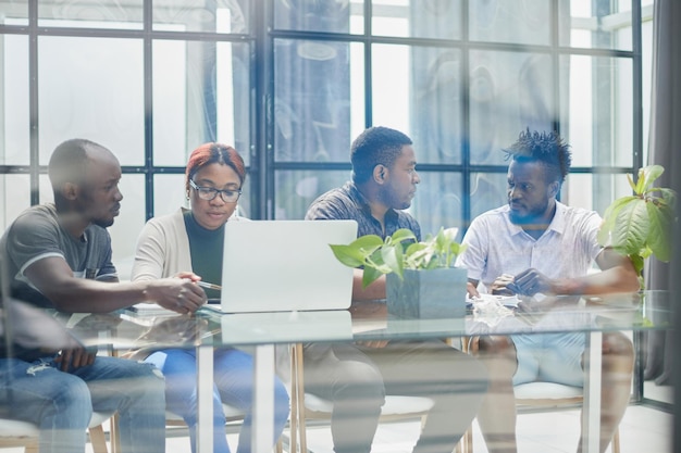 Dietro la vista vetrata dei dirigenti che discutono del progetto in un ufficio moderno