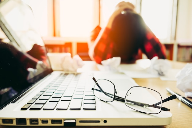 Difficile pensare all&#39;analisi del lavoro. Giovane uomo d&#39;affari asiatico sta lavorando alla pressione nell&#39;ufficio luminoso.