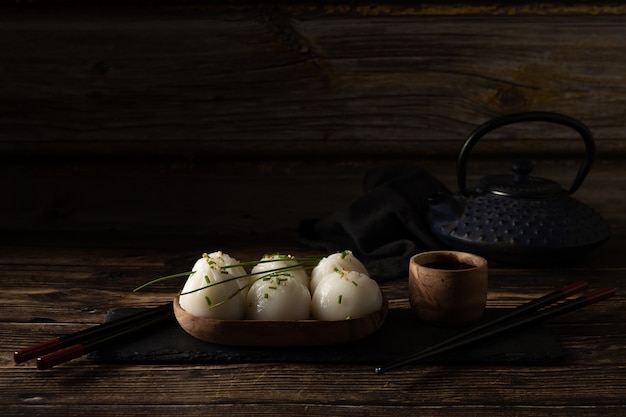 Dim sum di maiale e gamberi al vapore su pietra ardesia su tavola di legno