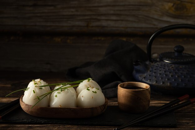 Dim sum di maiale e gamberi al vapore su pietra ardesia su tavola di legno