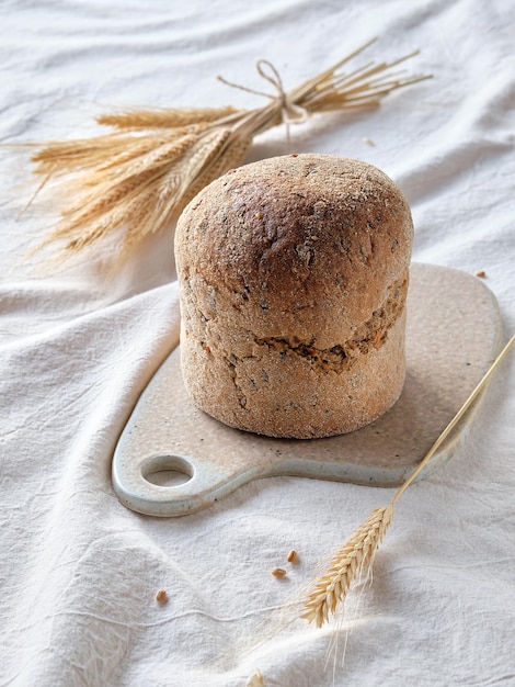 Dinkelbrot in tedesco significa pane integrale di farro. L'alternativa al grano. Il farro è un cereale antico coltivato con metodo biologico. Fuori bianco avorio sfondo tessile colore con spighe di grano.
