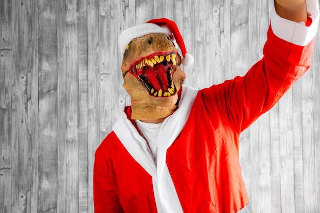 Dinosauro travestito da Babbo Natale che si fa un selfie