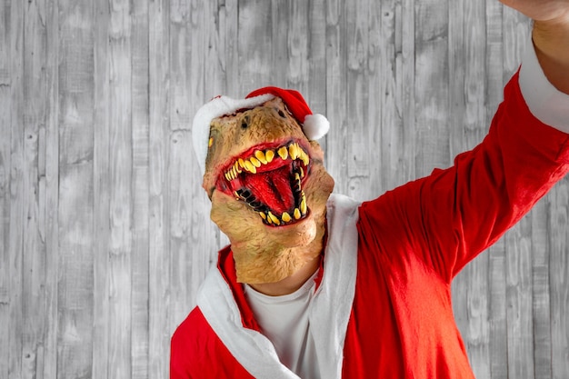 Dinosauro travestito da Babbo Natale che si fa un selfie