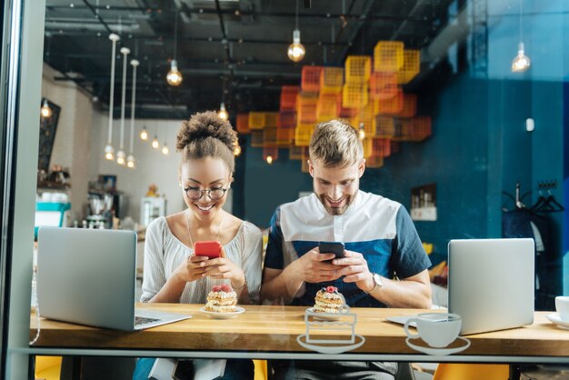 Dipendente da Internet. Coppia dipendente da Internet che si sente bene mentre fa foto dei loro dessert e caffè