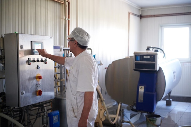 Dipendente maschio del casaro di produzione del formaggio che lavora in fabbrica