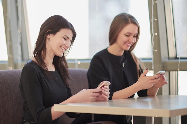 Dipendenti che utilizzano i loro smartphone seduti a un tavolo in un bar