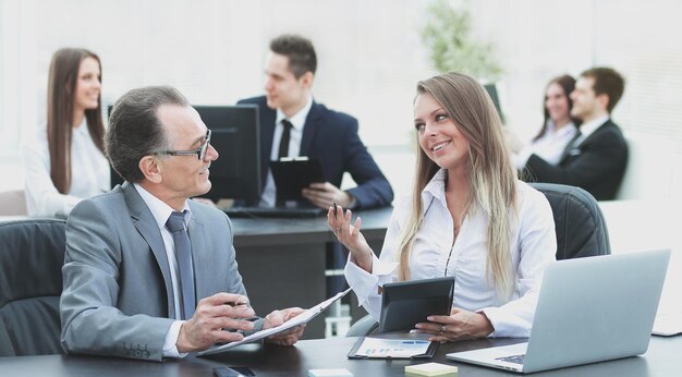 Dipendenti che utilizzano il tablet digitale per lavorare con i dati finanziari