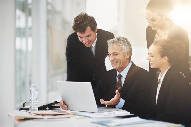 Dipendenti discussione e CEO con laptop in ufficio sorriso e tecnologia sulla scrivania per la pianificazione Colleghi felici e parlare con il capo del posto di lavoro in azienda aziendale per la strategia e gli affari