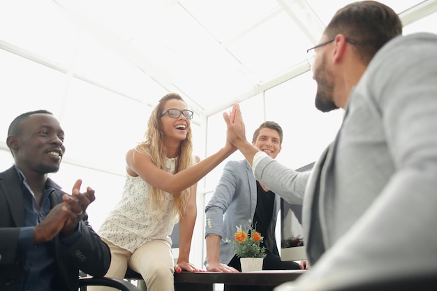 Dipendenti sorridenti che si danno il cinque il concetto di lavoro di squadra