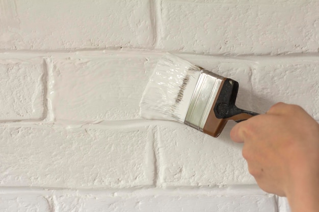 Dipingere un muro di mattoni bianchi in un colore bianco fresco