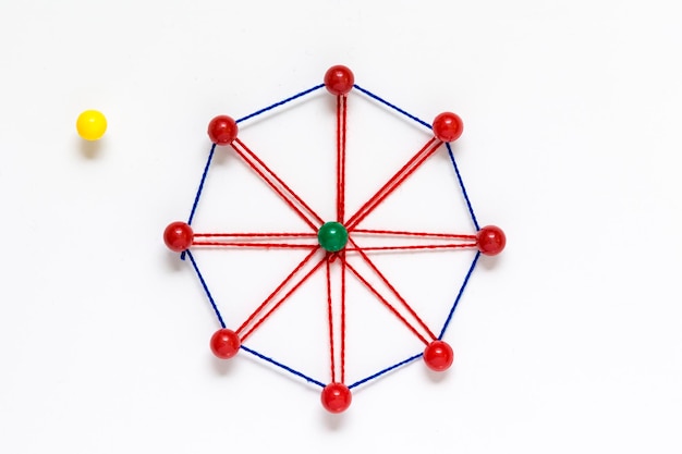 Directly above shot of design made with wool and thumbtack over white background