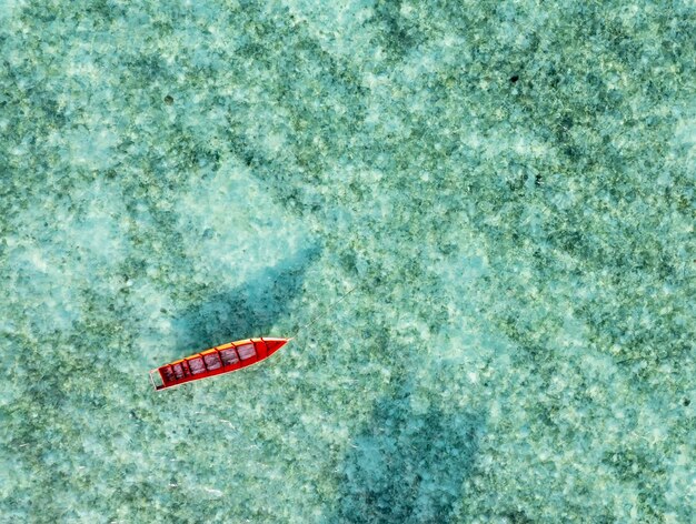 Direttamente sopra il colpo di barca di legno di colore rosso al mare tropicale