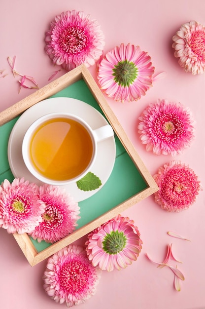 Direttamente sopra il colpo di tè con i fiori sul tavolo