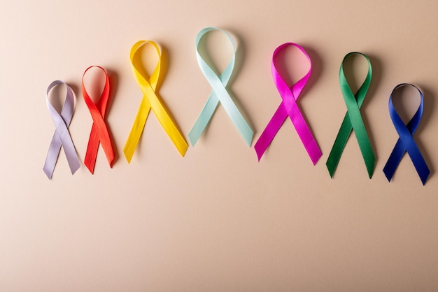 Direttamente sopra l'immagine di vari nastri multicolori di consapevolezza disposti su uno sfondo color pesca. copia spazio, cancro, malattia, medicina, nastro, consapevolezza, supporto, assistenza sanitaria e concetto di vigilanza.
