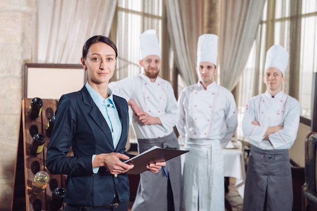 Direttore del ristorante e il suo staff in cucina. interagendo con lo chef in cucina commerciale.