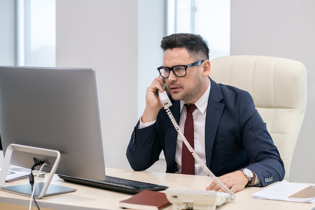 Direttore di azienda contemporanea che parla al telefono