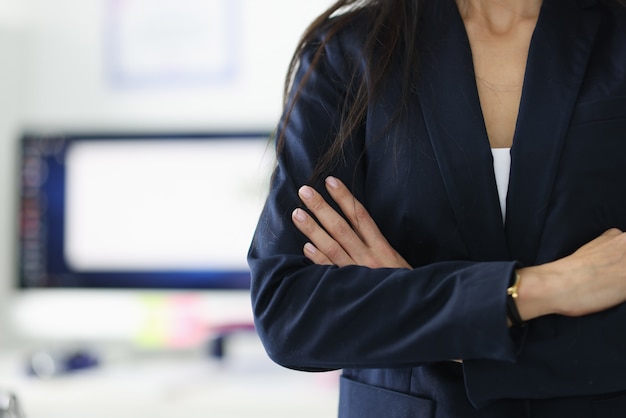 Direttore femminile in giacca nera in piedi in primo piano ufficio. Qualità di leadership nel concetto di donne