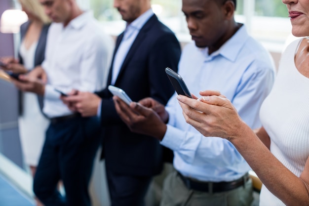 Dirigenti aziendali utilizzando la tavoletta digitale e il telefono cellulare