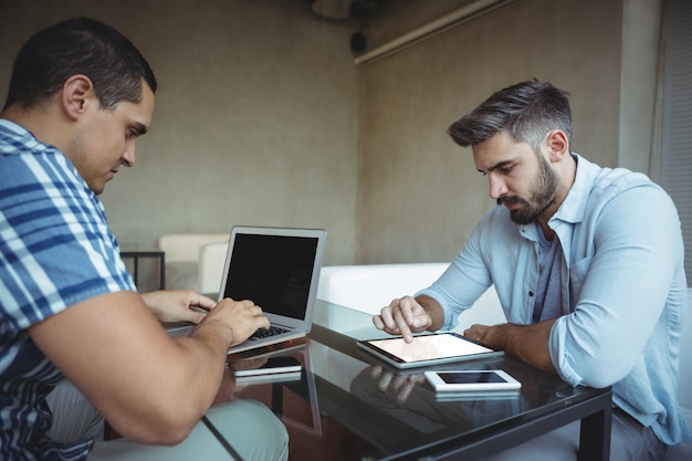 Dirigenti che utilizzano laptop e tablet digitale nella caffetteria