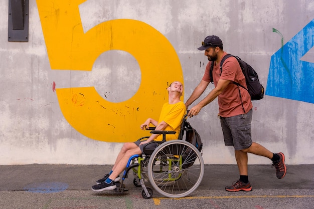 Disabile in sedia a rotelle con un muro di cemento che si diverte con un amico