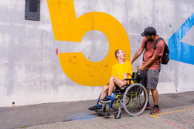 Disabile in sedia a rotelle con un muro di cemento che si diverte con un amico