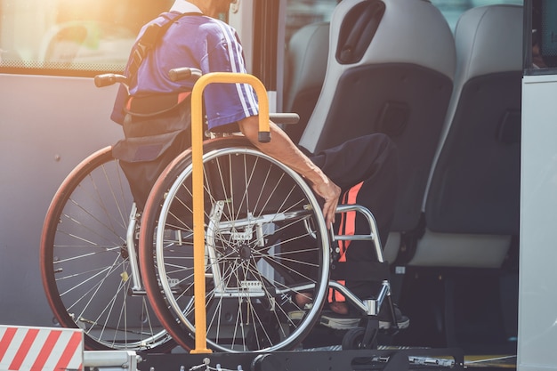 Disabili che si siedono sulla sedia a rotelle e che vanno al bus pubblico