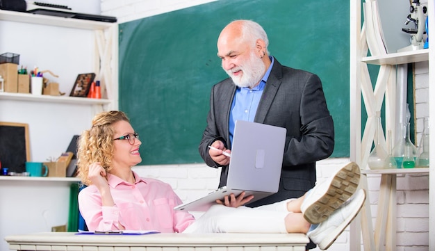 Discutere l'argomento con uno studente o un collega Uomo Insegnante di scuola superiore e studentessa spensierata con il laptop Scuola moderna Liceo universitario Comunicare in modo chiaro ed efficace